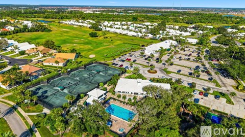 A bird's eye view of a residential area with a swimming pool and tennis courts.