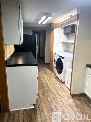 A kitchen with a black countertop and white cabinets.