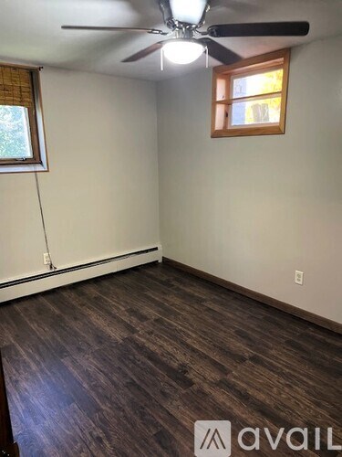A room with a ceiling fan and a window.