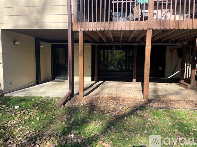 A wooden deck with a black door and windows.