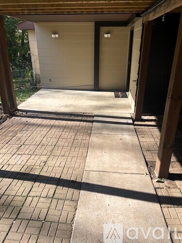 A garage with a brick floor and a white door.
