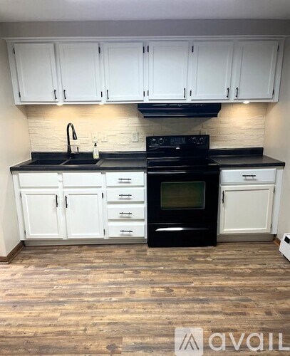 A kitchen with black countertops and white cabinets.