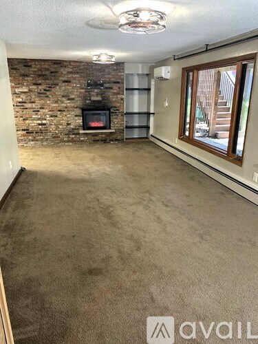 A room with a stone wall and a fireplace.