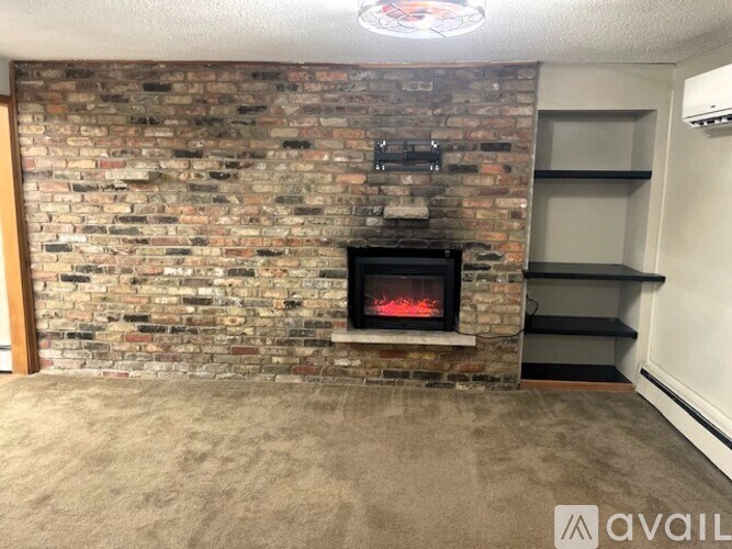 A room with a brick wall and a fireplace.