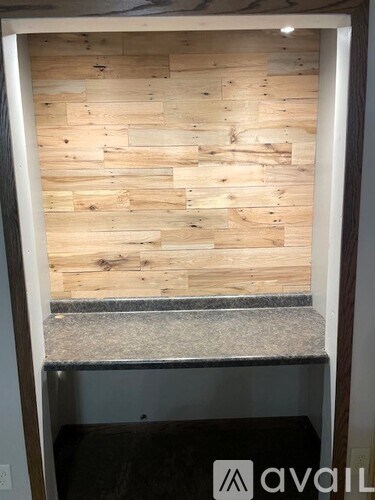 A wooden wall with a grey countertop and a white door.