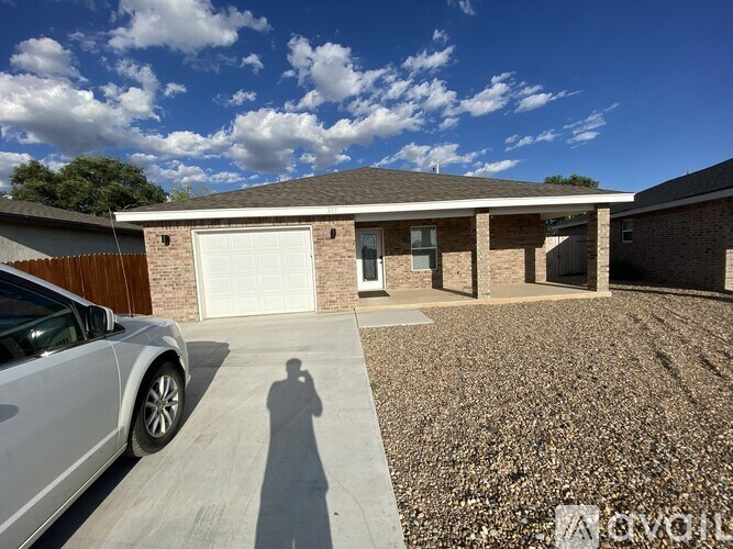 A house with a white car parked in front.