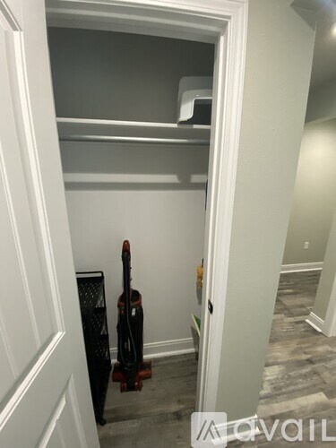 A guitar is leaning against a wall in a room with a white door.