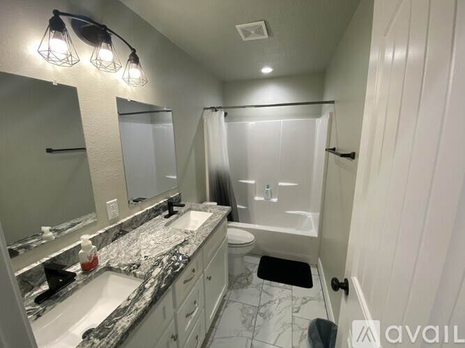 A bathroom with a marble countertop and a walk-in shower.