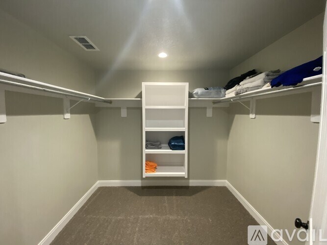 A white closet with shelves and clothes.