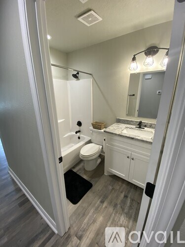 A bathroom with a toilet, sink, and mirror.