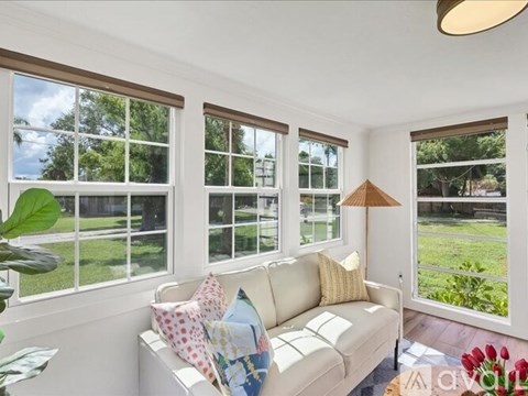 A living room with a white couch and a large window.