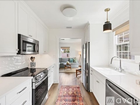A kitchen with white cabinets and a black stove top oven.