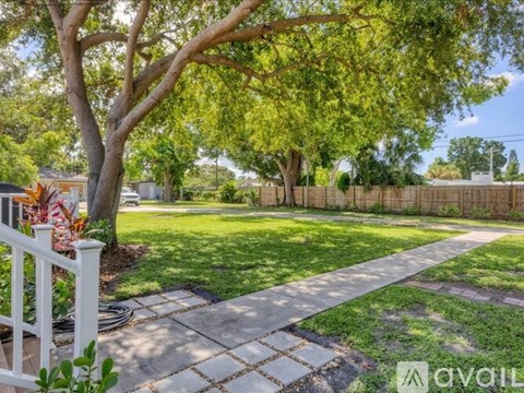A tree in a yard with a white fence.