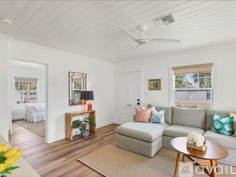 A living room with a grey couch and a wooden coffee table.