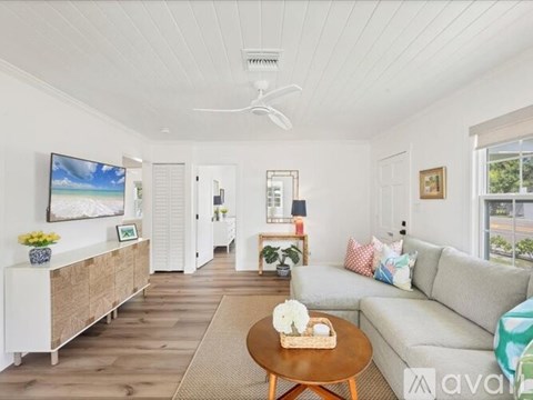 A living room with a couch, a coffee table, and a painting on the wall.