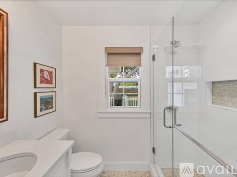 A bathroom with a toilet, sink, and shower.