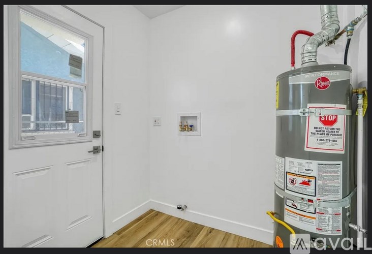 A room with a white door and a wall-mounted heater.