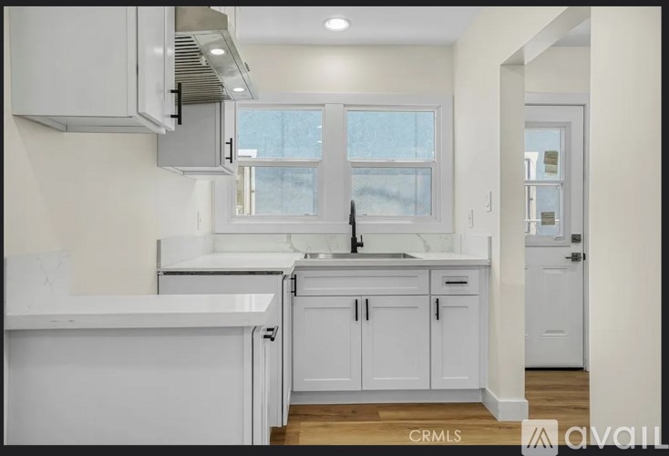 A white kitchen with a sink and cabinets.