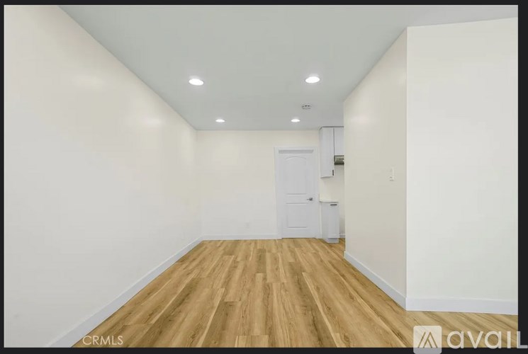 A room with wooden flooring and white walls.
