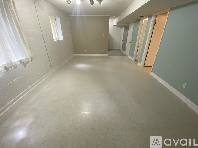 A spacious empty room with a window and a door.