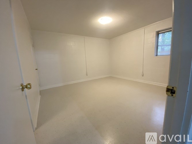 A small, empty room with a door and a window.