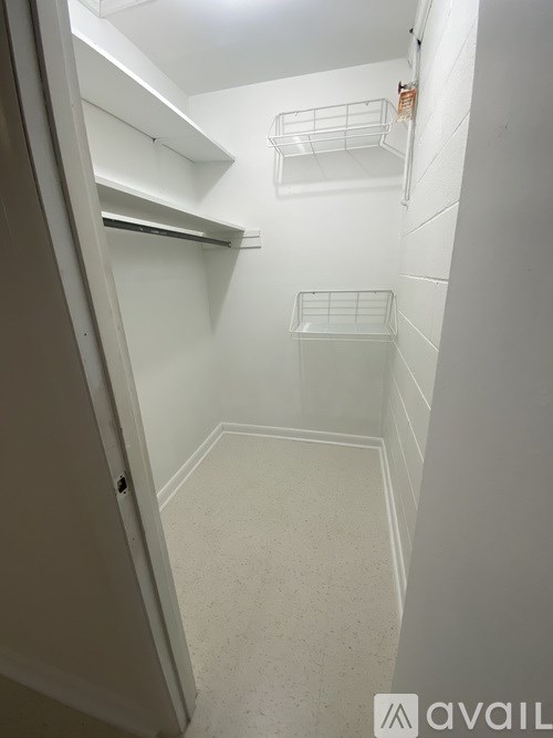A small, empty kitchen with white walls and a white floor.