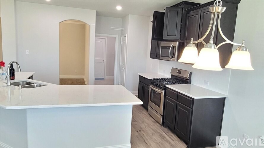 A kitchen with a white countertop and black cabinets.