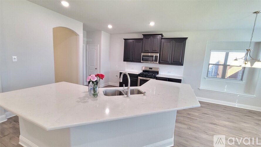 A kitchen with a white countertop and black cabinets.