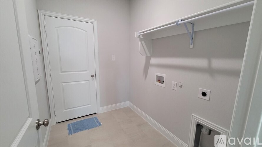 A white door is in a room with a blue rug on the floor.