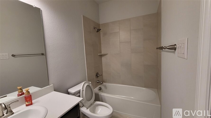 A bathroom with a toilet, sink, and bathtub.