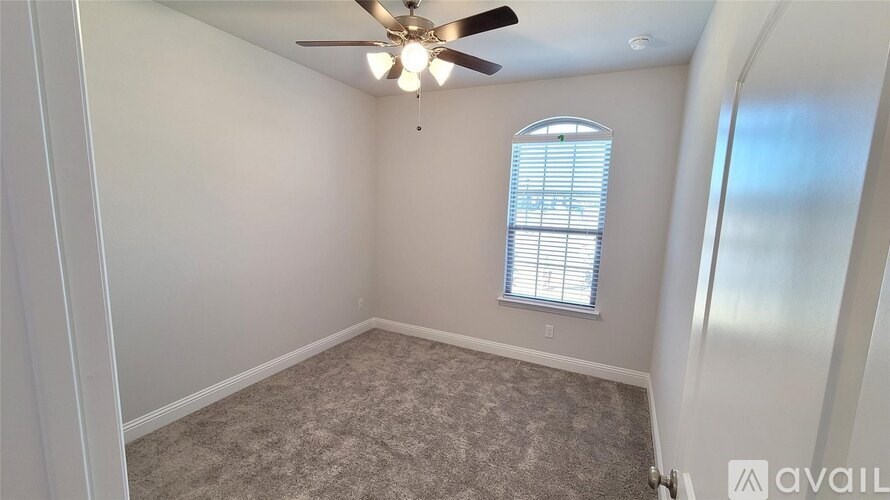 A room with a ceiling fan and a window with blinds.