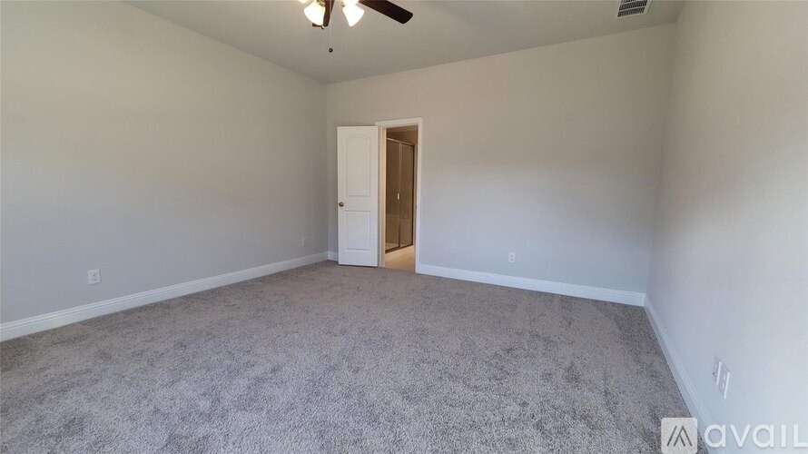 A room with a carpeted floor and a ceiling fan.