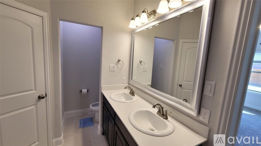 A bathroom with a sink, mirror, and toilet.