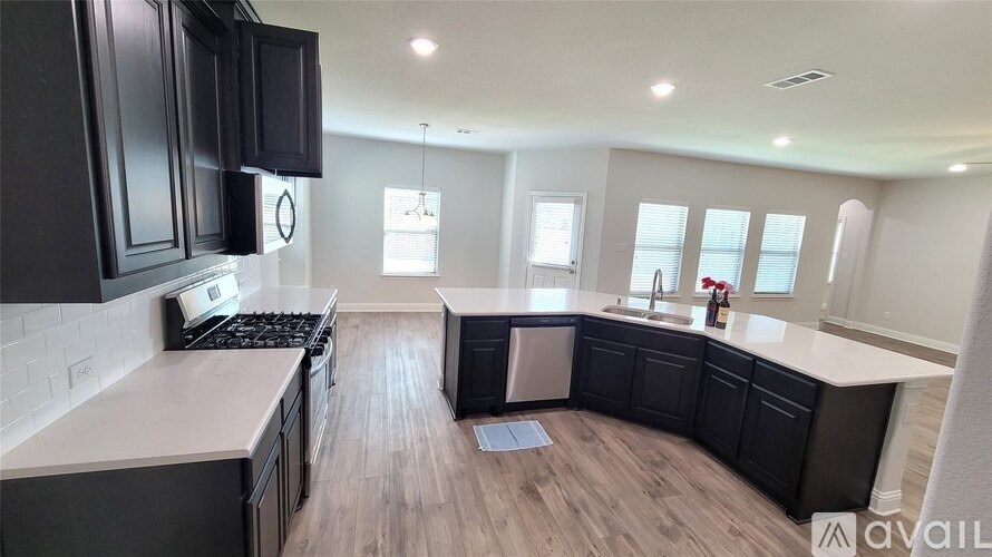 A modern kitchen with dark cabinets and a white countertop.