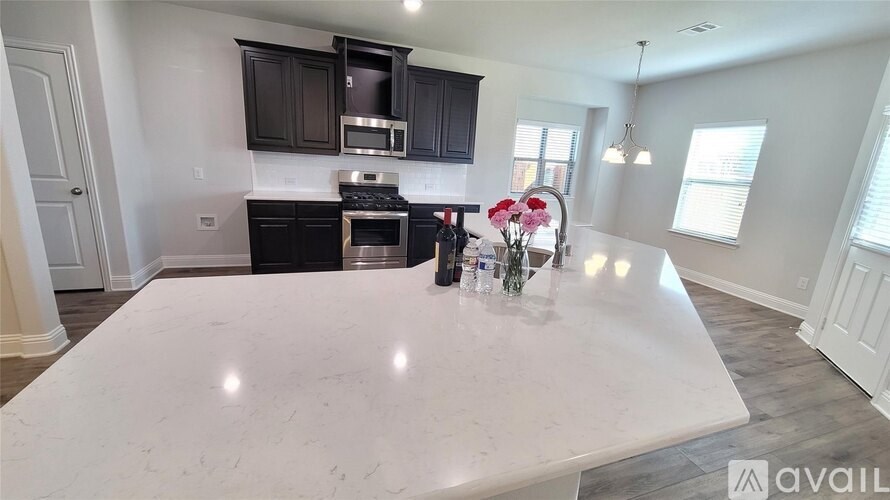 A kitchen with a white countertop and black cabinets is available for rent.