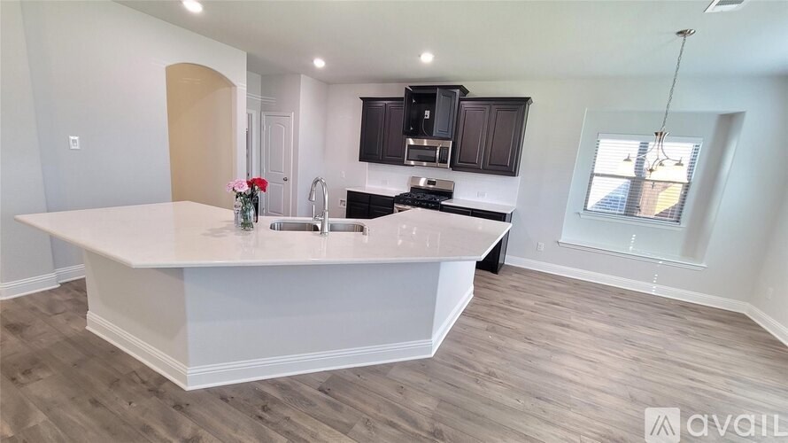 A kitchen with a white island and wooden floors.