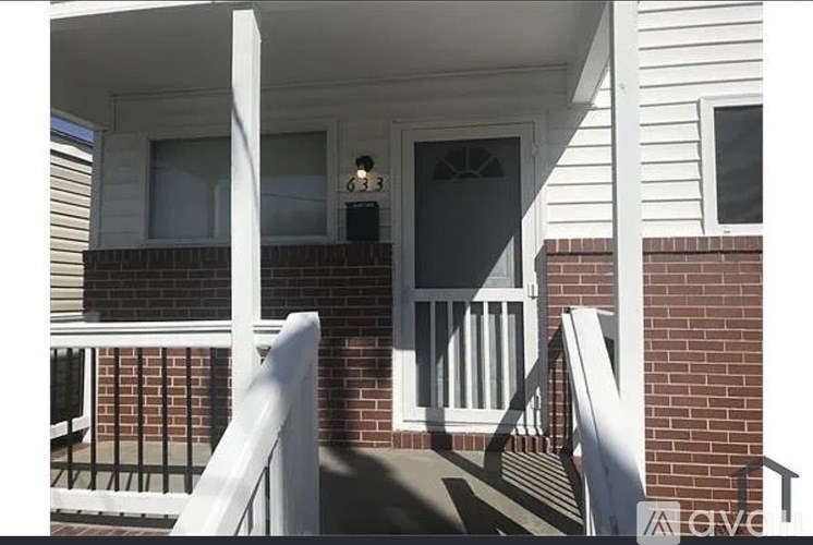 A white house with a balcony and a door.