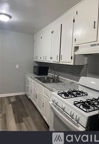 A kitchen with a white stove and cabinets.