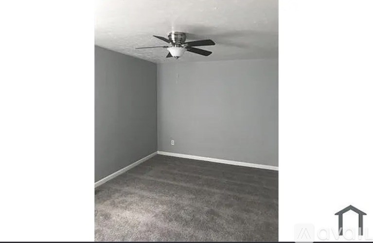 A room with a ceiling fan and carpeted floor.