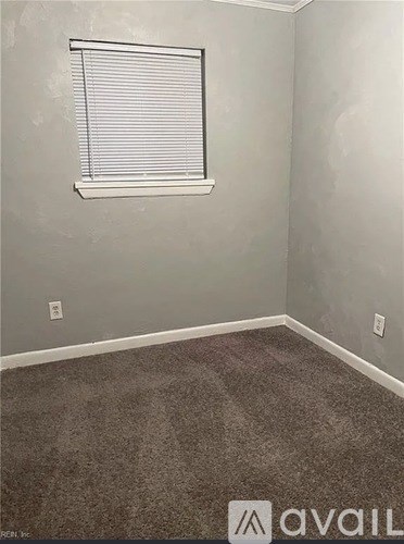 A room with a window and carpeted floor.