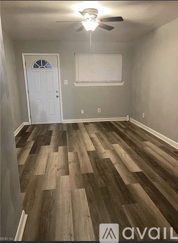 A room with wooden flooring and a white door.