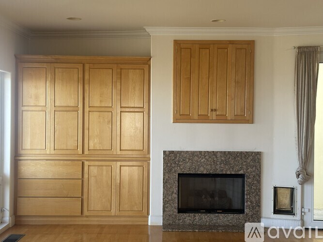 A living room with wooden cabinets and a fireplace.
