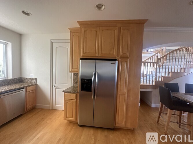 A kitchen with a refrigerator and a table.