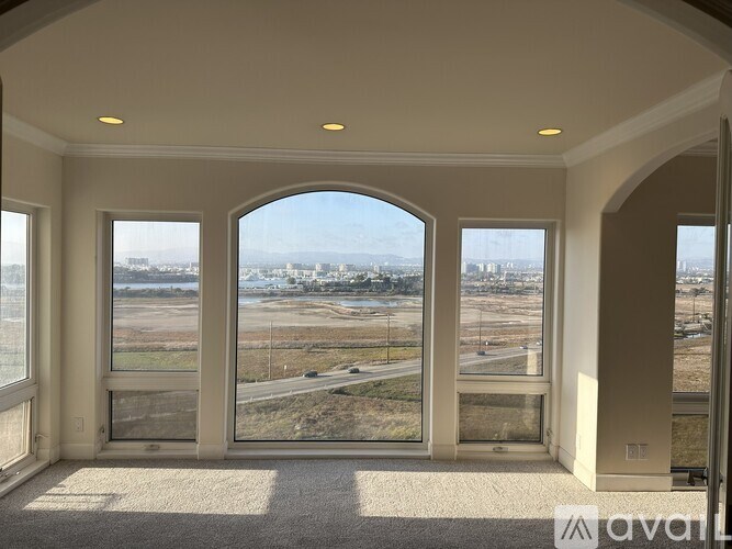 A room with a view of a highway and a cityscape.