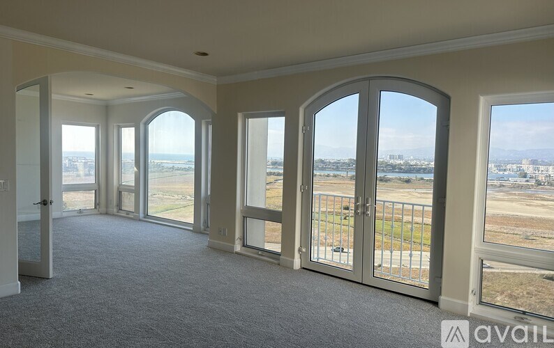 A spacious room with large windows and a view of the city.