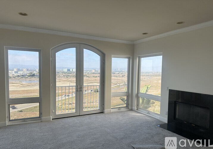 A living room with a fireplace and a view of the city.