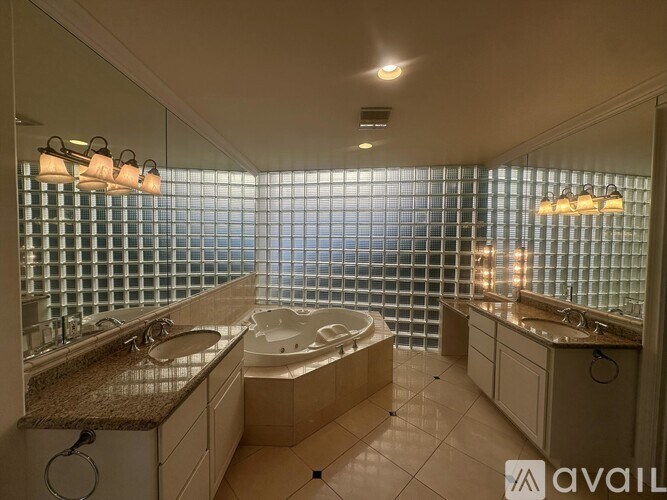 A bathroom with a large tub and double sinks.