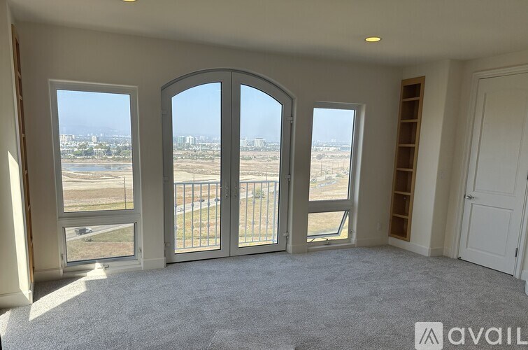 A room with a large window and a view of a cityscape.