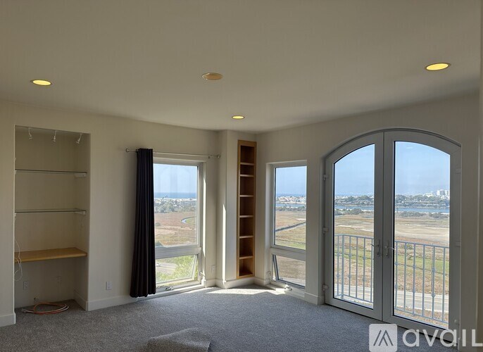 A spacious room with a view of the outside through large windows.