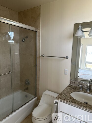 A bathroom with a toilet, sink, and shower.